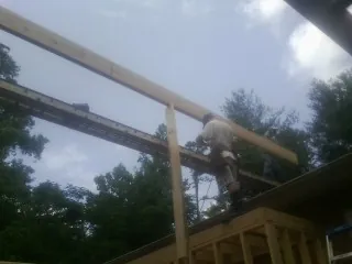 Carpenter setting a ridge beam over a new addition frame — Ice Dam Removal by Roofing Brothers in Newmarket