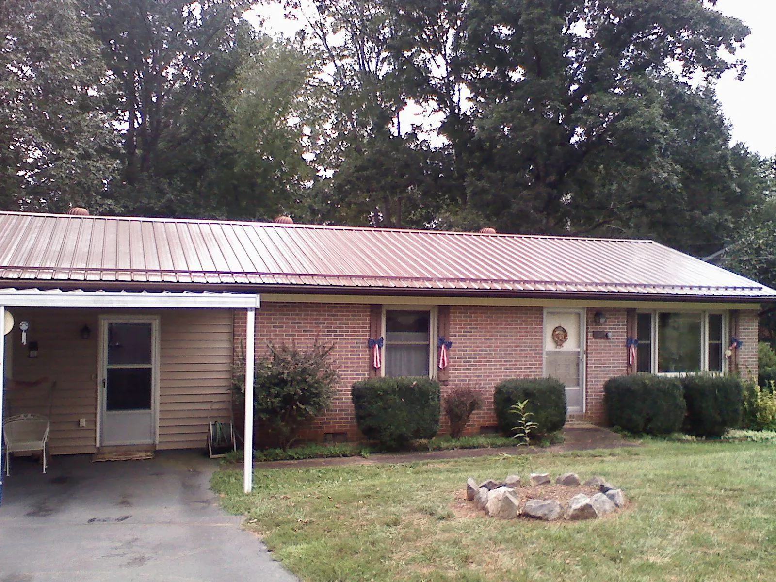 Bronze metal roof and carport on a brick ranch home — Roof Repair work by our crew in Newmarket